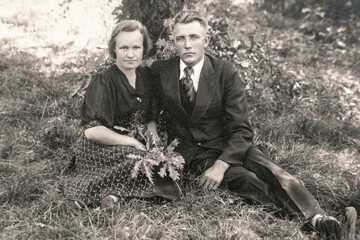 Germany - CIRCA 1930s: Man and woman sitting on ground in forest. Vintage archive Art deco era photo