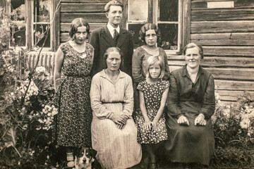 Latvia - CIRCA 1920s: Group portrait shot of five female and man outdoors next to entrance of...