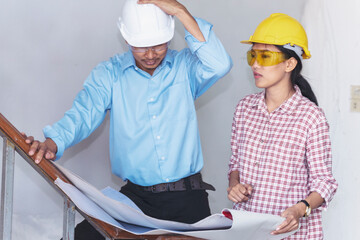 Fototapeta premium Construction engineer teamwork Safety Suit Trust Team Holding White Yellow Safety hard hat Security Equipment on Construction Site. Hardhat Protect Head for Civil Construction Engineer Concept