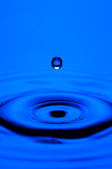 Closeup Shot of Abstract Blue Water Splash or Rain Drop Falling on Water Surface.