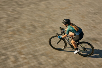 High angle view shot of professional female cyclist in cycling garment and protective gear looking...