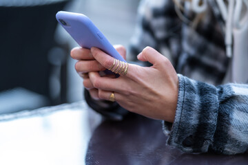 Detail of the hands of a woman with a smartphone with a rubber cover