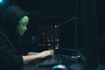 Anonymous hacker with mask on face, breaks the access to steal information and infect computers and systems. the concept of hacking and cyber war.