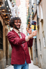 young man streaming outdoors using his mobile phone and a microphone