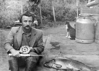 old vintage photo man with a fishing rod - obrazy, fototapety, plakaty