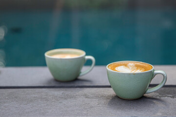 Cup of coffee with beautiful latte art on wooden table.