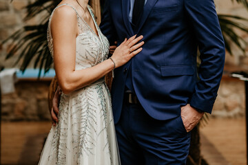 bride and groom holding hands on wedding day rings