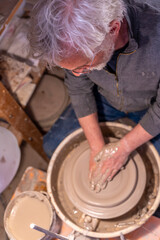 pottery craftsman working on a potters wheel to make a new bowl