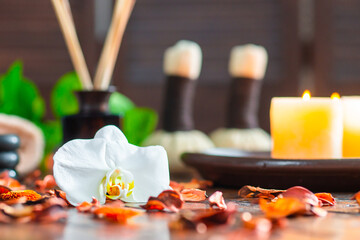 Spa background. Towel, candles, flowers, massaging stones and herbal balls. Massage, oriental therapy, wellbeing and meditation.