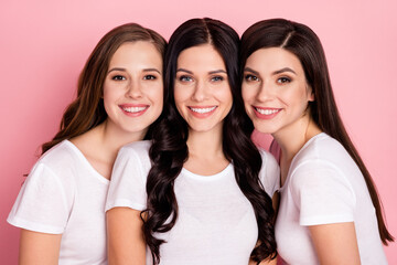 Photo of three cheerful young girls happy positive smile look charming girlfriends isolated over pink color background