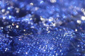 Wallpapers. Frozen movement of water. Drops of water falling and splashing. Sparkles, reflections of light. Vibrant blue color. 