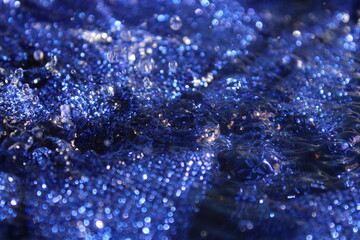 Wallpapers. Frozen movement of water. Drops of water falling and splashing. Sparkles, reflections of light. Vibrant blue color. 