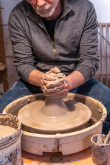 pottery craftsman working on a potters wheel to make a new bowl