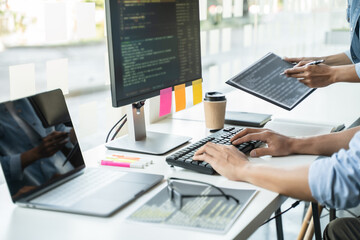 programmer writing program code with two monitors and working on a new software or hacker programming developing software applications