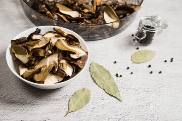 Close-up of dried porcini mushrooms on a plate, in a form for drying on a gray table. The concept...