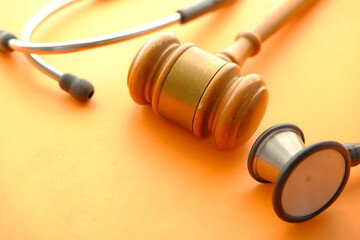 gavel and a stethoscope on orange background 