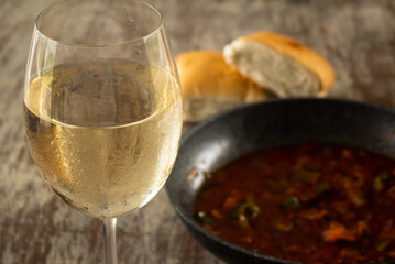 Round crystal glass with cold white wine. Rural rustic kitchen. Fermented grape juice.