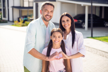 Portrait of three lovely adorable cheery family embracing showing heart shape sunny day dream in...