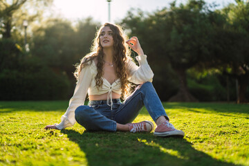 Chica joven guapa en parque disfrutando de un espacio verde en primavera