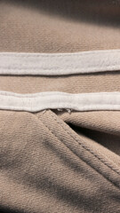 Tiras blancas cosidas en lateral de pantalón de chándal beige de algodón