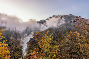 View of the Cervaiole marble quarry at sunset, partially covered by a low cloud, Seravezza, Apuan Alps, Italy