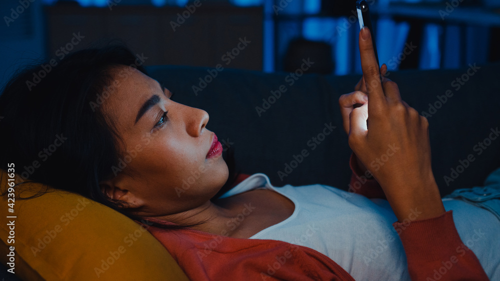 Wall mural Night time ​addict asian lady use smartphone sleep in bed at home feel boring and scrolling checking phone see message in online. Stay at home, Self quarantine,  Internet addiction and mobile abuse.