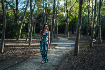 Chica guapa joven dando un paseo y tomándose fotos en un parque verde en primavera
