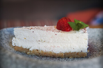 Slice of cheesecake with strawberries and mint