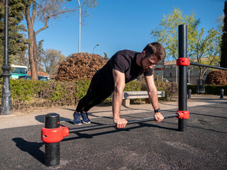 MAN DOING TRAINING STREET WORKOUT IN PARK