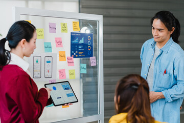 Group of Asia young creative people meeting brainstorming ideas conducting business presentation...