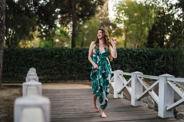 Chica joven guapa paseando por parque verde en primavera