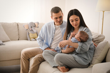 Happy family with cute baby on sofa at home