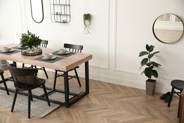 Stylish wooden dining table and chairs in room. Interior design