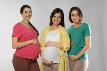 Happy young pregnant women on white background