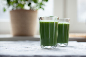 Pineapple, kiwi amd mint green smoothie on table. 