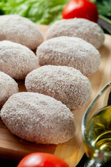 homemade natural farm cutlets on the table with vegetables and herbs.