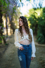 Chica joven guapa en un parque usando el smartphone y dando un paseo en primavera