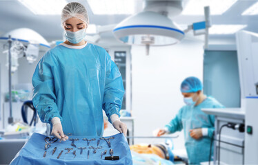 Nurse near table with different surgical instruments in operating room