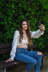 Chica en un banco en un parque verde en primavera