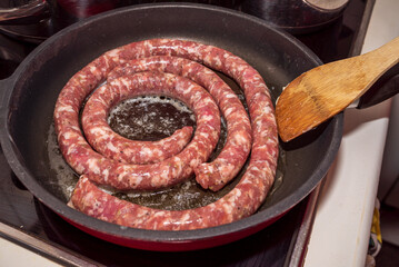 Long fresh sausage in the pan