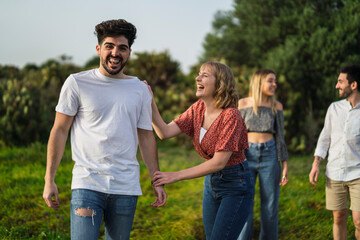 Grupo de amigos disfrutando de zona verde en primavera tomando selfies