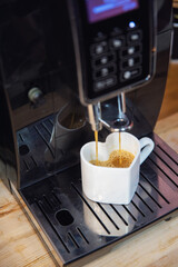 White cup in the Pink jars with a green twig and pieces of marmaladeform of a heart with coffee and a coffee machine
