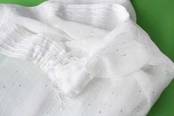 Natural cotton. White curtain on a green background.