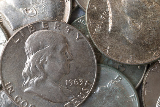 Benjamin Franklin and Kennedy half dollar silver coins close view.