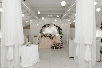 a beautiful wedding table decorated with flowers and wedding decor stands in the middle of the wedding banquet. empty party hall during quarantine. wedding food.