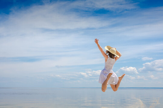 happy young woman jumping on the beach
