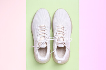 Stylish sporty sneakers on color background, top view