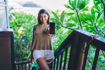 Ethnic woman demonstrating smartphone with black screen