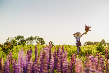 Happy woman jumping on blossom meadow