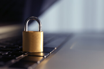 Metal padlock on laptop keyboard, space for text. Cyber security concept